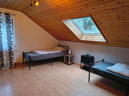 a attic room with two beds and a skylight at Hostel Fantasy in Gröbenzell