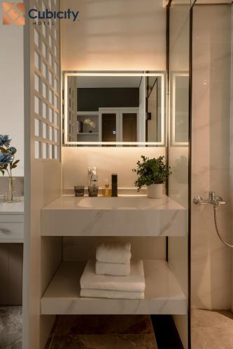 a white bathroom with a sink and a shower at Cubicity Ton That Tung in Ho Chi Minh City