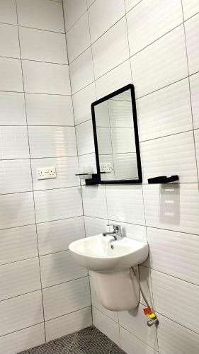 a bathroom with a sink and a mirror on the wall at Muyenga Studio Apartments in Kampala