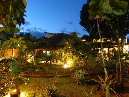 a garden in front of a house at night at Pousada das Bromélias in Porto De Galinhas