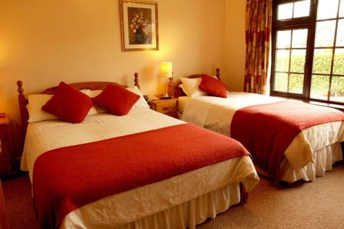 ナヴァンにあるAthlumney Manor Guest Accommodationのベッド2台と窓が備わるホテルルームです。