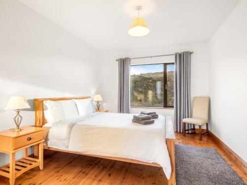 a bedroom with a bed and a window at Makeelan House in Renvyle
