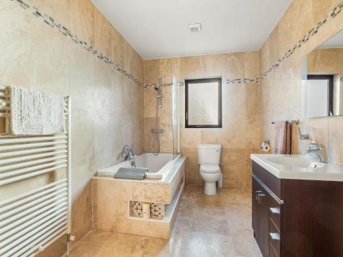 a bathroom with a tub and a toilet and a sink at Makeelan House in Renvyle