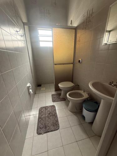 a bathroom with a toilet and a sink at Pousada Matriz 2 in Ouro Fino