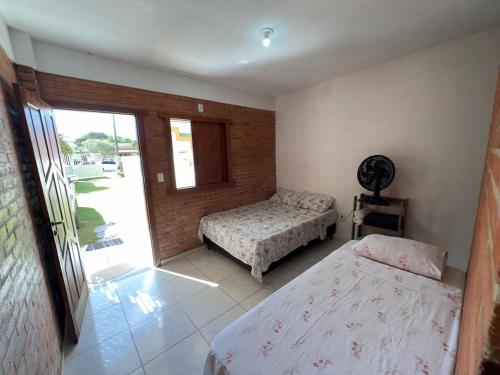 a bedroom with two beds and a sliding glass door at HOSTEL NATIVOS in Linhares