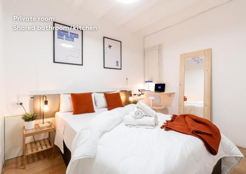 a bedroom with two beds with white sheets and orange pillows at weroomies - Pons Icar H1 in Tarragona