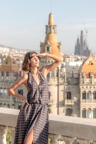 a woman in a dress sitting on a ledge at BLESS Barcelona - New Opening 2026 in Barcelona