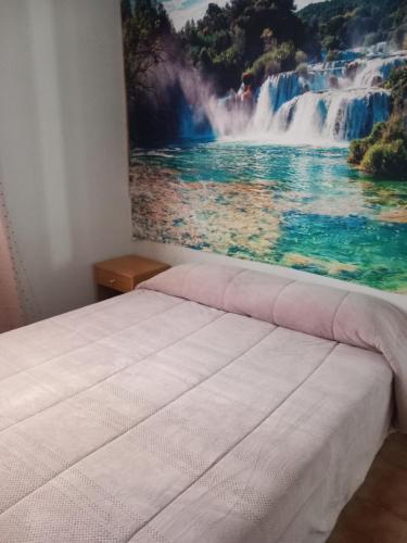 a bedroom with a painting of a waterfall at Entre els pirineus in La Seu d'Urgell