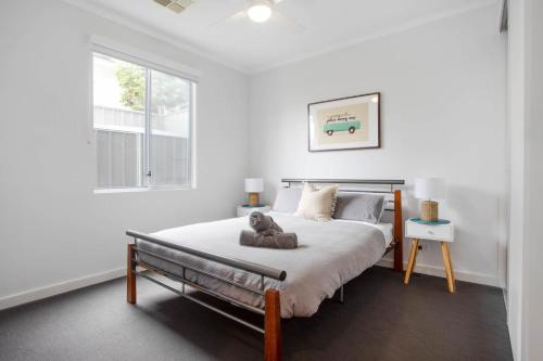 a white bedroom with a bed and a window at Atlantis - Coastal Retreat near Horseshoe Bay in Port Elliot