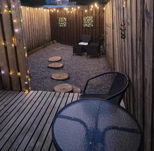 a patio with a table and chairs and lights at Kaoglen Warren - Pet friendly - Hot Tub - Cairngorms in Blairgowrie