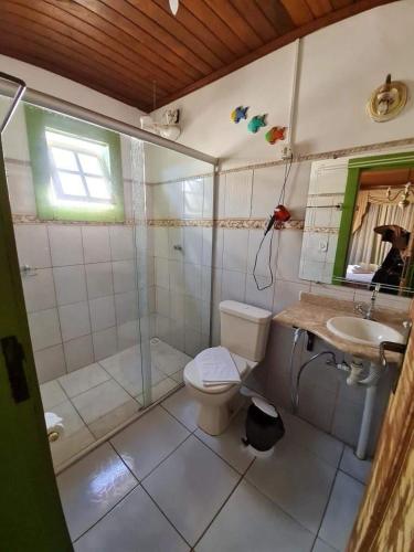a bathroom with a toilet and a shower and a sink at Pousada Joaninha in Tiradentes