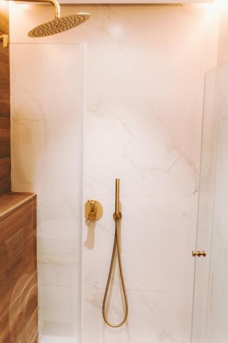 a shower with a hose hanging on a wall at Stylish Penthouse Beach Front in Ashkelon