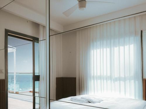 a bedroom with a bed and a large window at Stylish Penthouse Beach Front in Ashkelon
