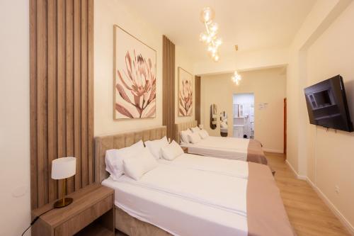 a bedroom with two beds and a tv at Hotel MB in Metković