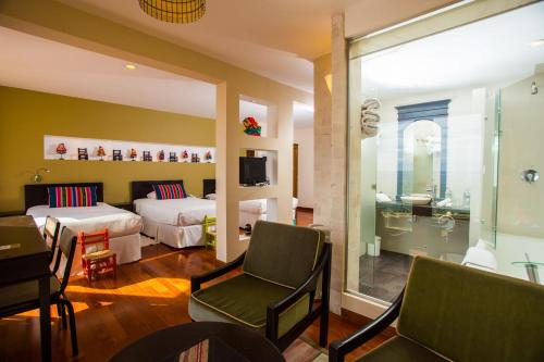 a hotel room with two beds and a table and chairs at Hotel Rosario Lago Titicaca in Copacabana
