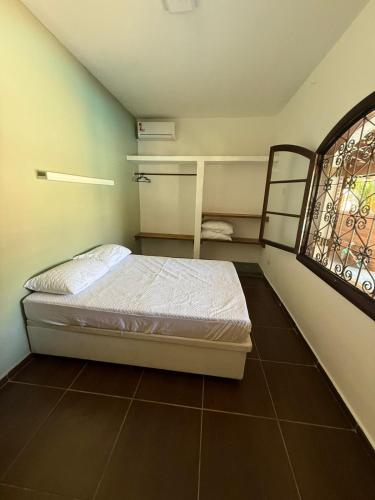 a small bedroom with a bed and a window at Casa Itaguá in Ubatuba