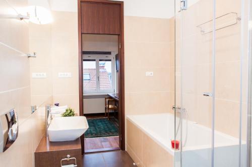 a bathroom with a tub and a sink and a shower at Centroom Apartment Zagreb in Zagreb