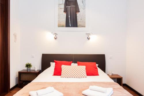 a bedroom with a bed with red pillows at Centroom Apartment Zagreb in Zagreb