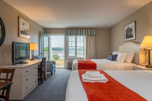 a hotel room with two beds and a television at Sebasco Harbor Resort & Golf Club in Sebasco Estates