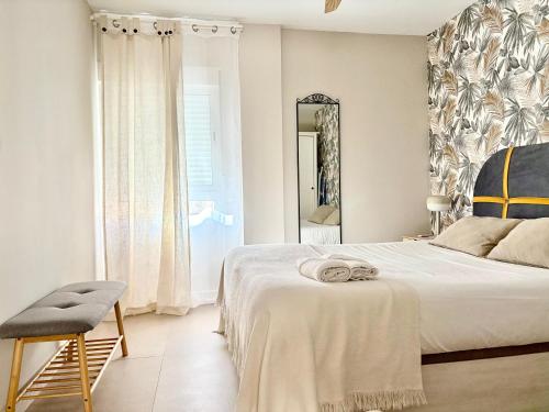 a bedroom with a bed and a chair and a mirror at cultura y playa in Puerto de Sagunto