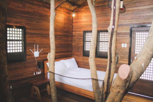 a bed in a room with trees in it at Treehouse Executive Villas - ANGELES in Malino