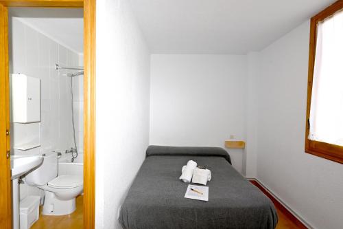 a bathroom with a bed and a toilet and a sink at Habitacions La Coma de Taüll in Taüll