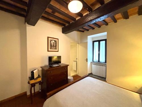 a bedroom with a bed and a tv and a window at Residenza Le Logge in Gubbio