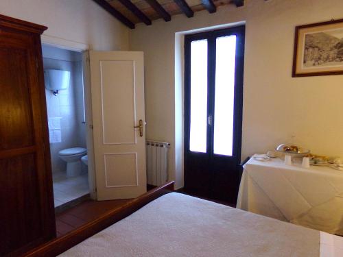 a room with a door leading to a bathroom with a toilet at Residenza Le Logge in Gubbio