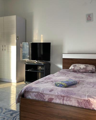 a bedroom with a bed and a flat screen tv at Rix Hostel Oda Kiralama, Ortak Banyo Mutfak in Kyrenia