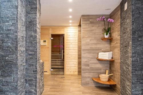 a bathroom with a stone wall and a shelf at Hotel Europe App 303 in Davos