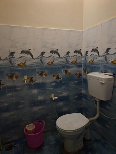 a bathroom with a toilet and ducks on the wall at Yamuna Bank Inn in Prayagraj