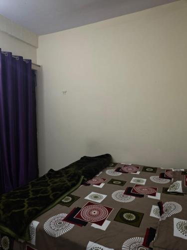 a bed with a quilt on it in a room at Yamuna Bank Inn in Prayagraj
