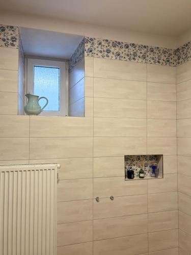 a bathroom with a window and a vase on the wall at Chalupa u dědy in Kozlov