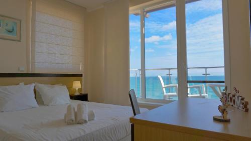 a bedroom with a bed with a view of the ocean at Apartments Obzor Beach C - Апартаменти Обзор Бийч С in Obzor