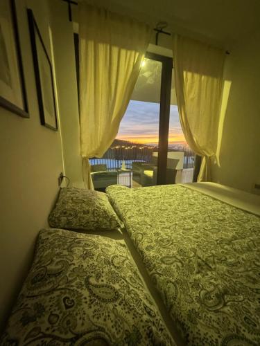 a bedroom with a bed and a large window at Cozy apartment Kosmaj Residence in Rogača