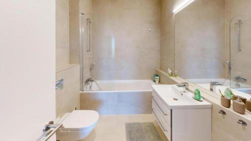 a bathroom with a tub and a toilet and a sink at Apartment FreshOlive in Trnávka