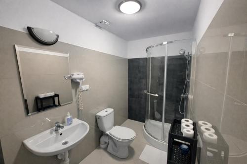 a bathroom with a toilet and a sink and a shower at Hotel Bukowiec in Legionowo