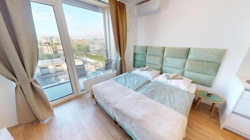 a bedroom with a bed and a large window at Apartment FreshOlive in Trnávka