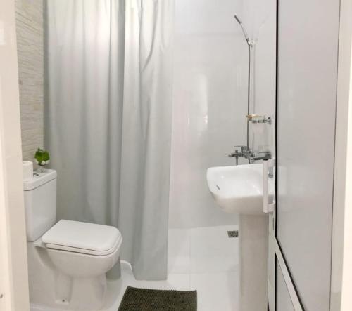 a white bathroom with a toilet and a sink at Ayona Beach Villa in Katuneriya