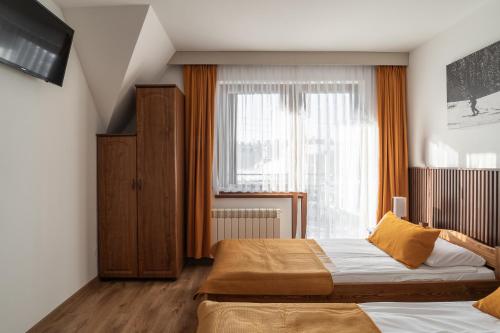 a bedroom with two beds and a window at Willa Bukowina in Bukowina Tatrzańska