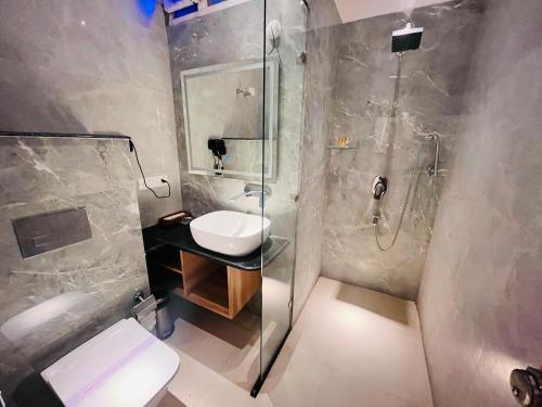 a bathroom with a shower and a sink and a toilet at Grove Residency Huaz Khas New Delhi - Couple Friendly in New Delhi