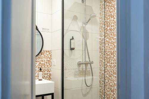 a bathroom with a shower and a sink at The Originals City, Hôtel Les Océanes, Lorient in Lorient