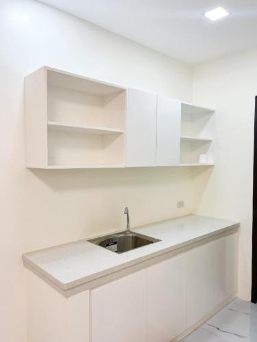 a kitchen with white cabinets and a sink at Treehouse Executive Villas - ANGELES in Malino