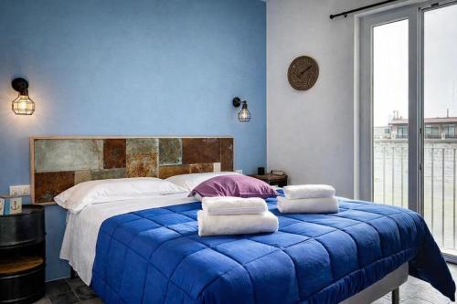a blue bedroom with a large bed with pillows on it at Hotiday Polignano Centro - Fico d'India in Polignano a Mare