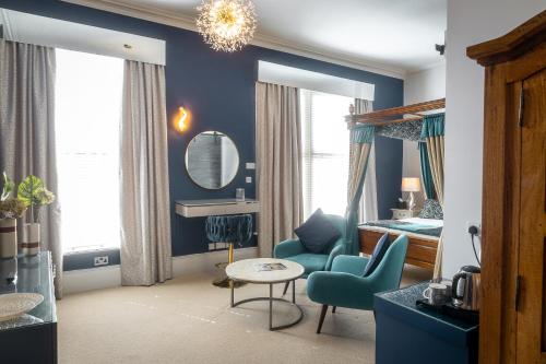 a living room with blue walls and a mirror at Herriots Hotel in Skipton
