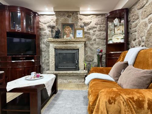 a living room with a couch and a fireplace at Casa Carlinhos da Carreira in Terras de Bouro