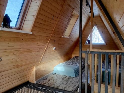an attic room with a bed in a wooden cabin at М'юзіка Карпат in Yavoriv