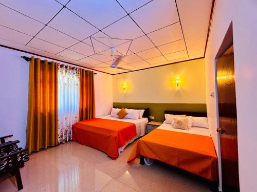 a hotel room with two beds and a ceiling at Luna Fortuna Villa in Tangalle