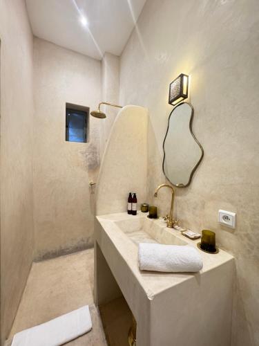 ein Badezimmer mit Waschbecken und Spiegel in der Unterkunft Riad Sumud in Marrakesch