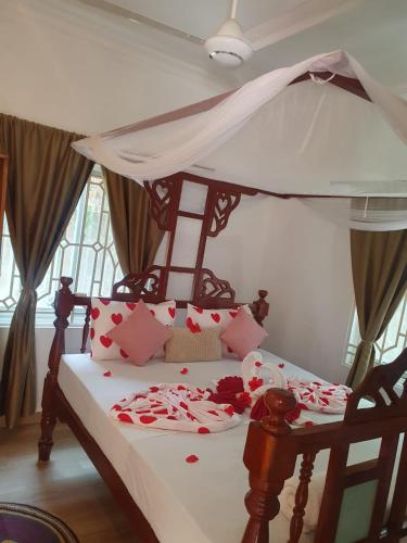 a bedroom with a bed with a canopy with hearts at White Jaguar House in Bwejuu
